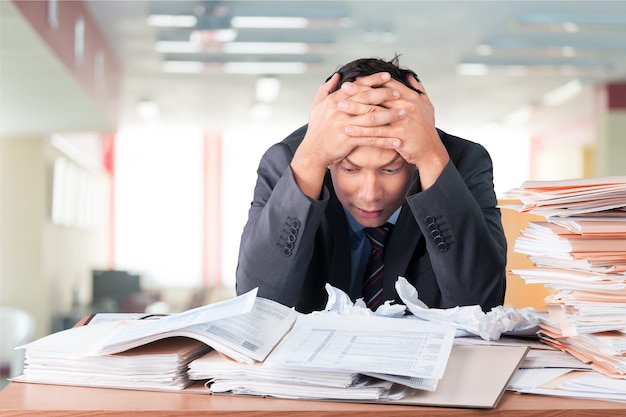 Hombre de negocios joven en traje gris cansado del trabajo