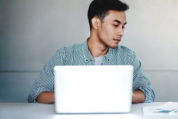 Hombre de negocios joven Working en la computadora portátil en oficina.