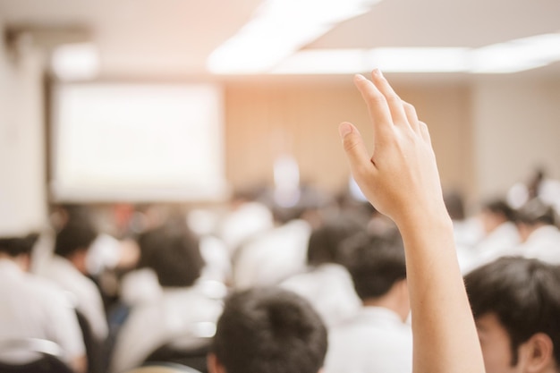 hombre de negocios levantando la mano durante el seminario. Empresario levantando la mano en una conferencia para responder una pregunta.