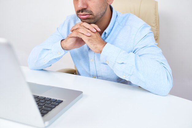 Hombre de negocios leyendo un correo electrónico aburrido