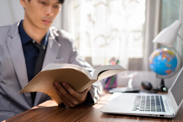 Hombre de negocios leyendo un libro en su escritorio