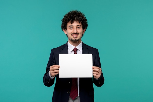 Hombre de negocios lindo chico guapo en traje de oficina negro sonriendo y sosteniendo una hoja de papel