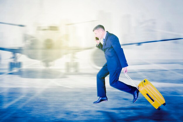 El hombre de negocios lleva equipaje y corre rápido en el aeropuerto