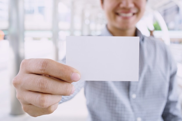 Hombre de negocios en mano sostenga mostrar tarjeta blanca en blanco con esquinas redondeadas.