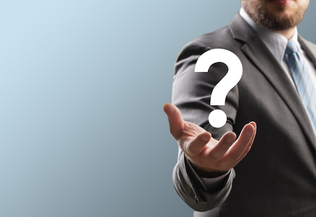 hombre de negocios con la mano sosteniendo un signo de pregunta concepto de signo de cuestión y preguntas frecuentes hacer preguntas en línea
