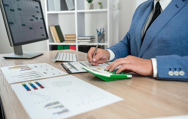 hombre de negocios mano trabajando con computadora y contabilidad informe anual con documento de negocios