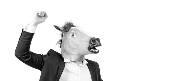 Hombre de negocios en máscara de cabeza de caballo con caballo de batalla de gesto de fuerza de puño levantado