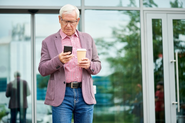 Hombre de negocios mayor que se coloca al aire libre