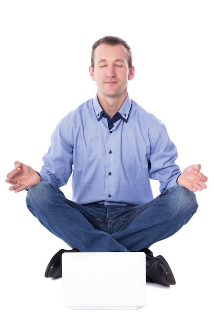 Hombre de negocios de mediana edad sentado en pose de yoga con portátil aislado sobre fondo blanco.
