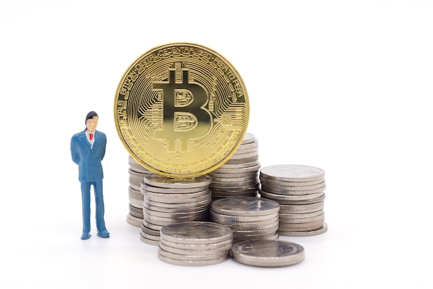 Hombre de negocios miniatura y Bitcoin en el fondo blanco