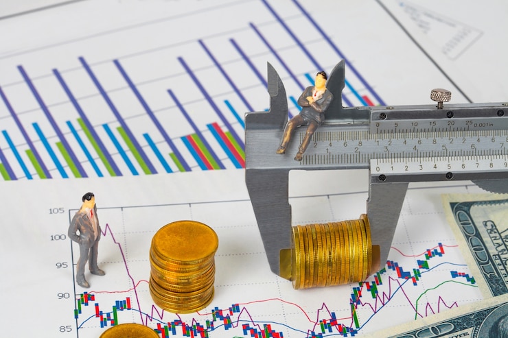 Hombre de negocios en miniatura y vernier medir monedas de dinero