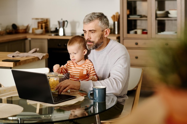 Foto un hombre de negocios mirando la pantalla de su portátil.