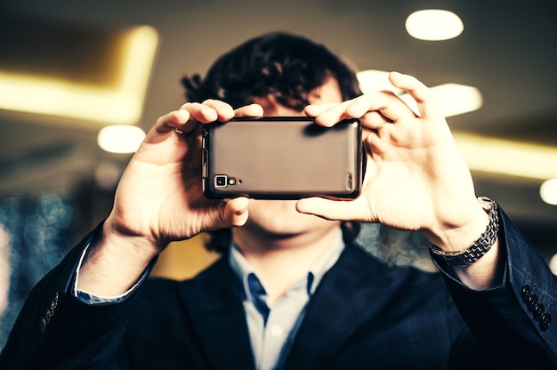 Hombre de negocios mirando en la pantalla del teléfono inteligente