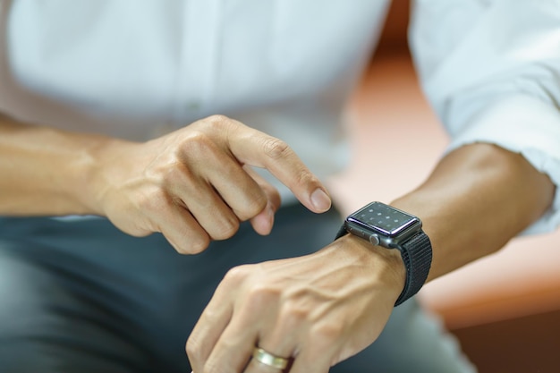 Hombre de negocios mirando reloj inteligente en Office conexión en línea tecnología Gadget