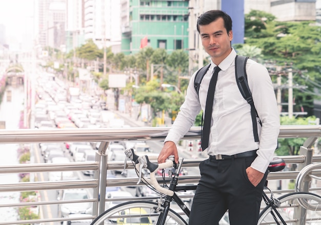 Hombre de negocios moderno es ciclismo bicicleta para trabajar para evitar atascos en la ciudad ocupada