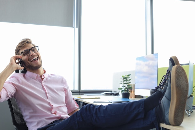 Foto hombre de negocios moderno hablando por teléfono mientras está sentado en la oficina.