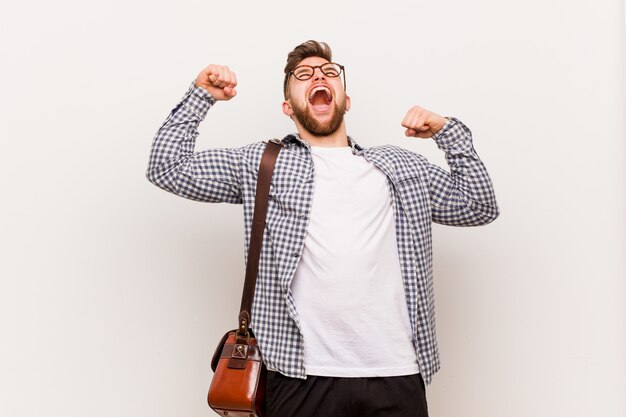 Hombre de negocios moderno joven que levanta el puño después de una victoria, concepto ganador.