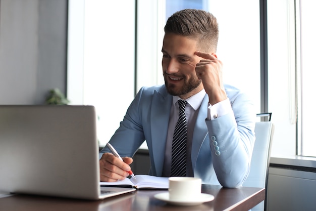 Hombre de negocios moderno pensando en algo mientras está sentado en la oficina.