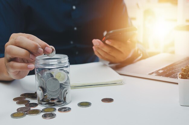hombre de negocios con una moneda ahorrando dinero en una jarra de vidrio finanzas empresariales inversiones contabilidad concepto impositivo