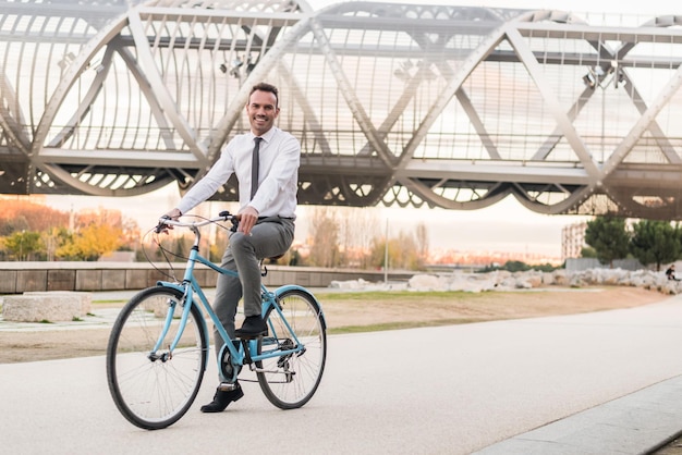 Hombre de negocios montando una bicicleta vintage en la ciudad