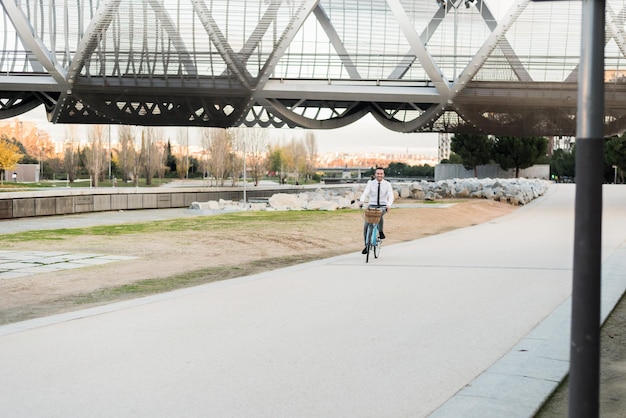 Hombre de negocios montando una bicicleta vintage en la ciudad