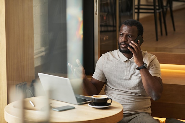 Hombre de negocios negro adulto trabajando en café