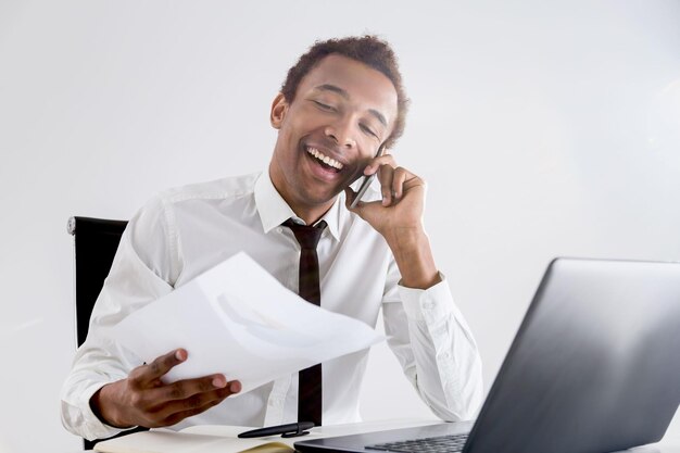 Hombre de negocios negro sonriente en el teléfono