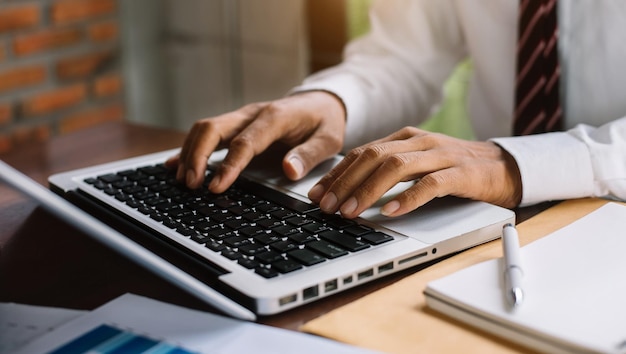 Hombre de negocios o estudiante usando una computadora portátil en casa Hombre manos escribiendo en el teclado de la computadora primer plano aprendizaje en línea marketing en Internet trabajando desde casa