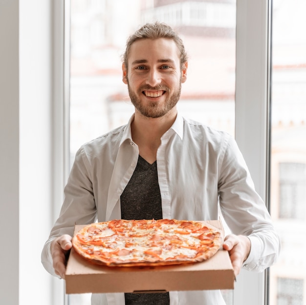 Foto hombre de negocios en la oficina con pizza