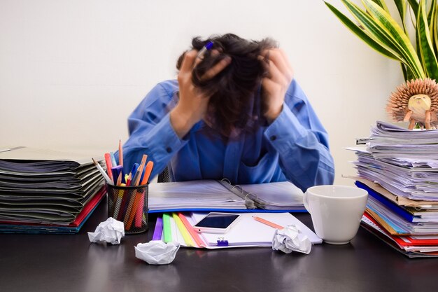 Hombre de negocios en la oficina con síndrome de burnout en el escritorio