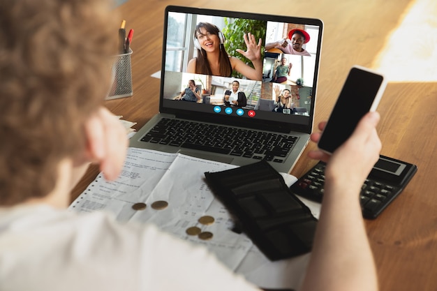 El hombre de negocios participa en la videoconferencia mirando la pantalla del portátil durante la reunión virtual, la aplicación de cámara web de videollamada para negocios, de cerca. Trabajo remoto, autónomo, educación, concepto de estilo de vida.