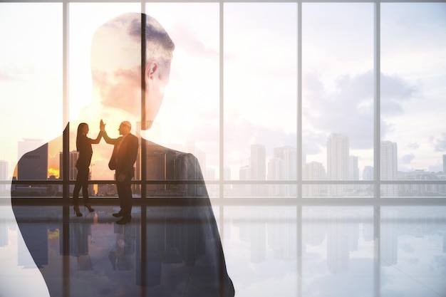 Hombre de negocios pensativo de pie en el interior de la ciudad abstracta con vista a la luz del sol y lugar simulado Lluvia de ideas sobre el futuro del trabajo en equipo y el concepto de éxito Doble exposición