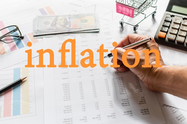 Un hombre de negocios con una pluma y comprobando números en situaciones de inflación severa en todo el mundo Concepto de finanzas tasas de interés bancarias economía Primer plano Fondo borroso