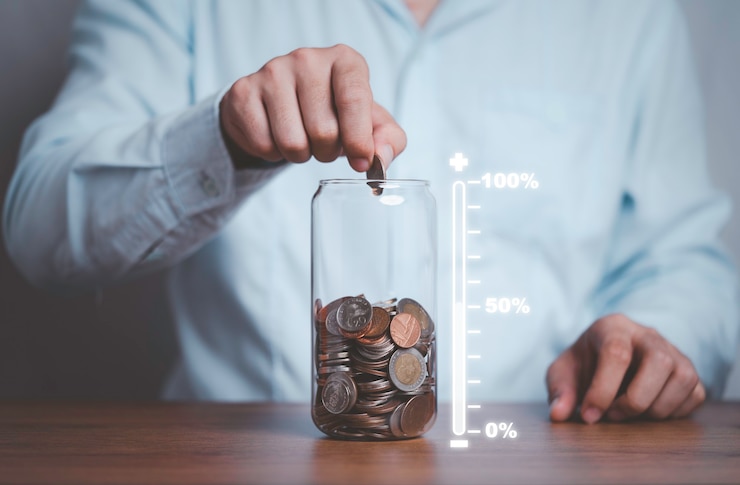 Foto hombre de negocios poniendo monedas al tarro de ahorro de dinero con escala virtual de cantidad de ahorro para el futuro.