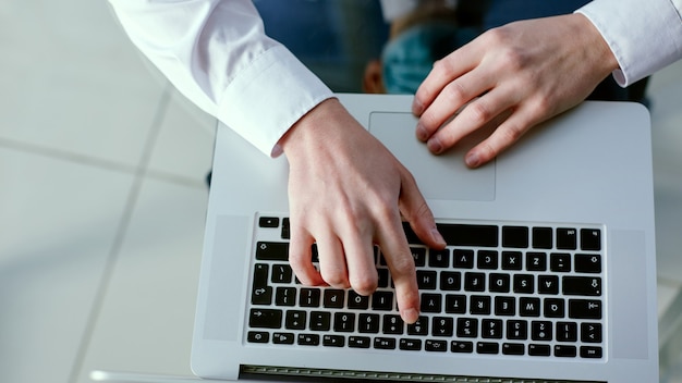 Hombre de negocios presionando una tecla con el número en su computadora portátil