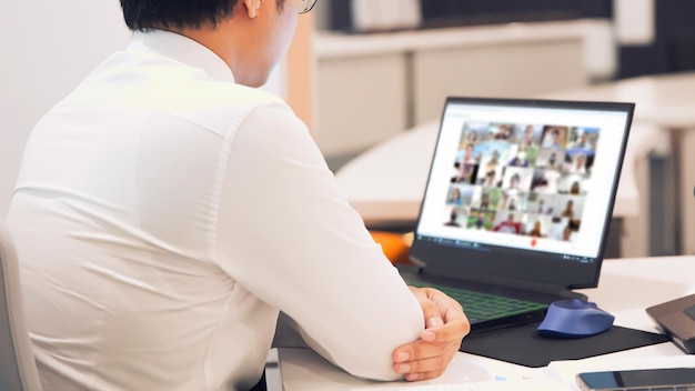 Foto hombre de negocios de primer plano utiliza computadora portátil para reuniones en línea.