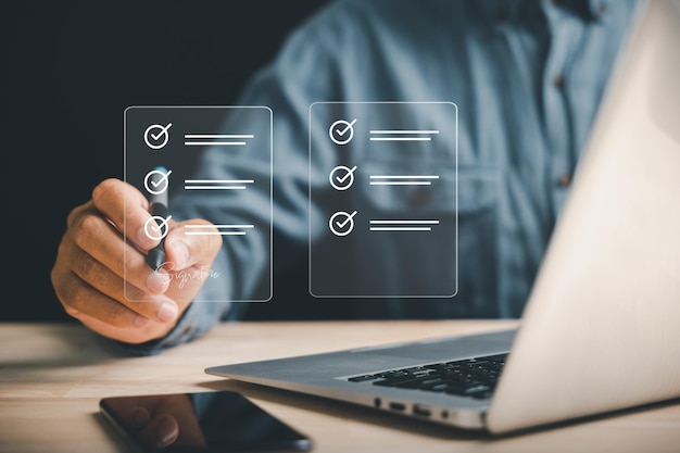 Un hombre de negocios profesional utiliza un bolígrafo para firmar documentos electrónicos en una pantalla virtual Muestra el diseño del concepto de oficina sin papel y la gestión eficaz de documentos Se establece un acuerdo