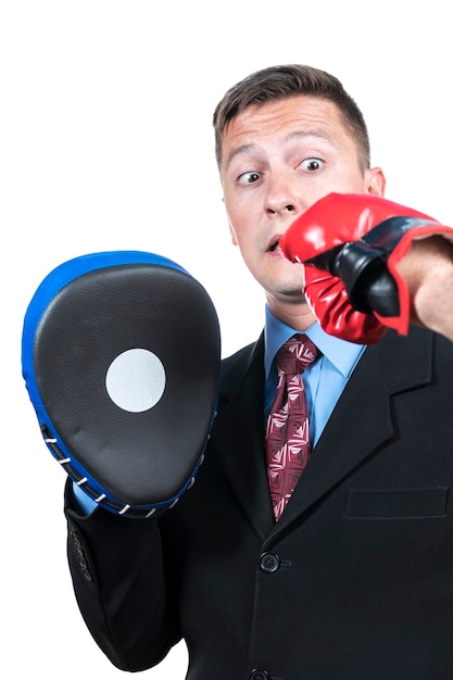 El hombre de negocios con un puñetazo recibe una patada en la cabeza con un guante de boxeo, aislado en un fondo blanco