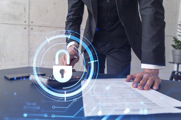 Foto un hombre de negocios que calcula la probabilidad de riesgos en la protección de la seguridad cibernética usando una calculadora iconos de holograma de candado sobre el escritorio de trabajo ropa formal