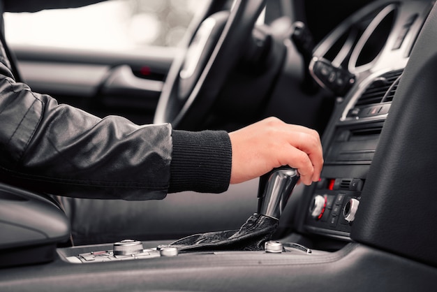 Hombre de negocios que conduce el coche moderno de lujo en la ciudad.