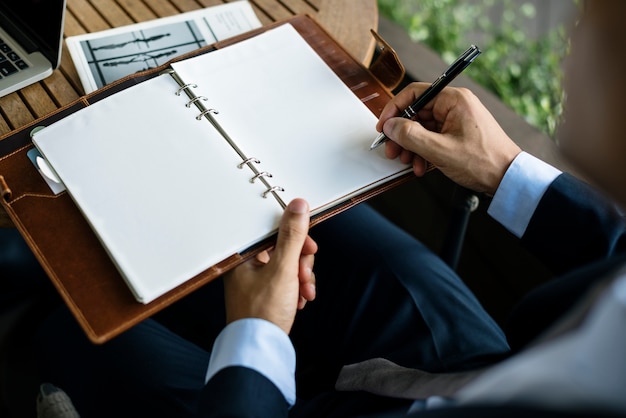 Hombre de negocios que escribe una nota en un cuaderno