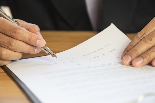 Foto hombre de negocios que firma un contrato. posee el signo empresarial personalmente.