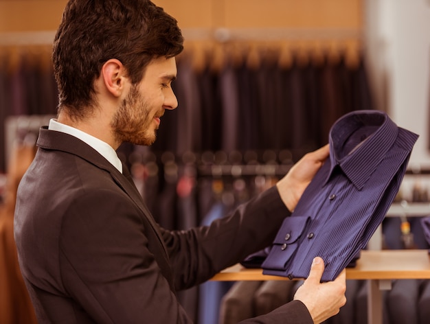 Hombre de negocios que mira y que elige la camisa clásica.