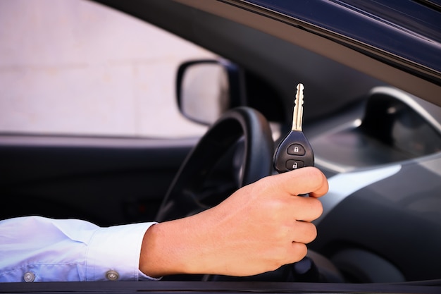 hombre de negocios que muestra una llave del coche