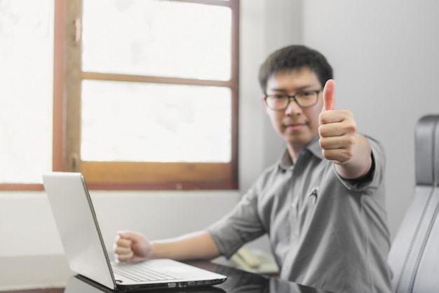 Hombre de negocios que muestra su pulgar para arriba, éxito de la celebración de la gente que trabaja concepto acertado