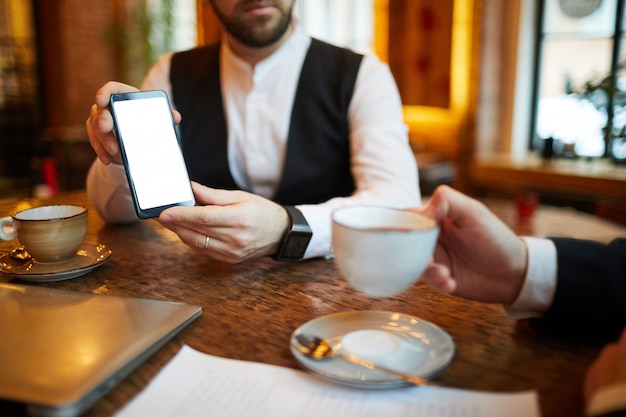 Hombre de negocios que muestra el teléfono móvil