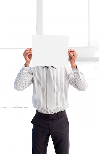 Hombre de negocios que presenta una tarjeta blanca frente a su cara