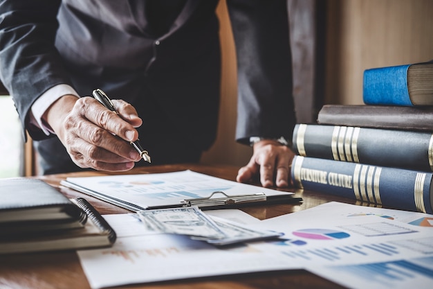 Hombre de negocios que señala en el gráfico y el gráfico para uso de análisis para planes para mejorar la calidad