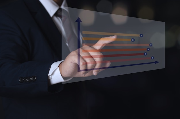 Hombre de negocios que señala el punto en la tabla de finanzas del gráfico. Fondo de gráfico de finanzas de gráfico de holograma de negocio digital. Para el concepto de negocios y finanzas.