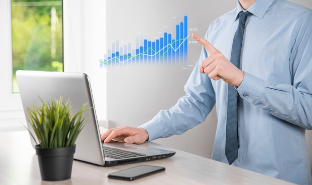 Hombre de negocios que sostiene la tableta y que muestra gráficos holográficos y estadísticas del mercado de valores obtiene ganancias. Concepto de planificación del crecimiento y estrategia empresarial. Visualización de pantalla digital de buena forma económica.